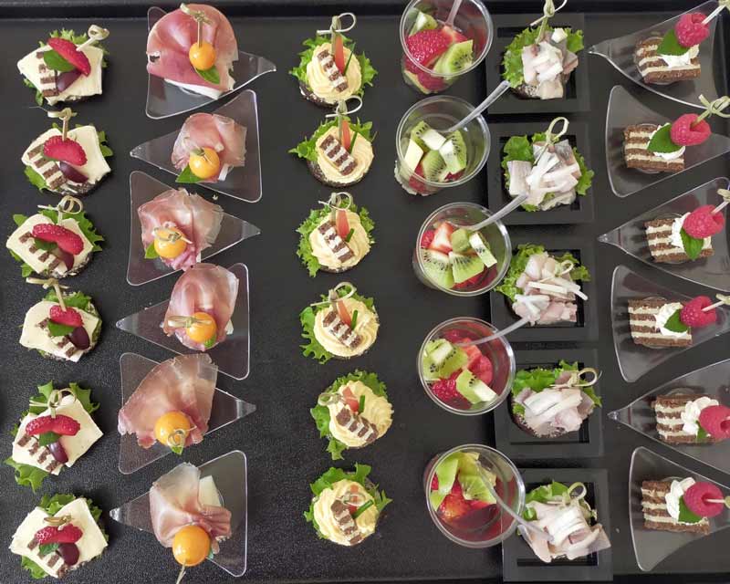 Platte mit verschiedenen Häppchen und Fingerfood in kleinen Schälchen