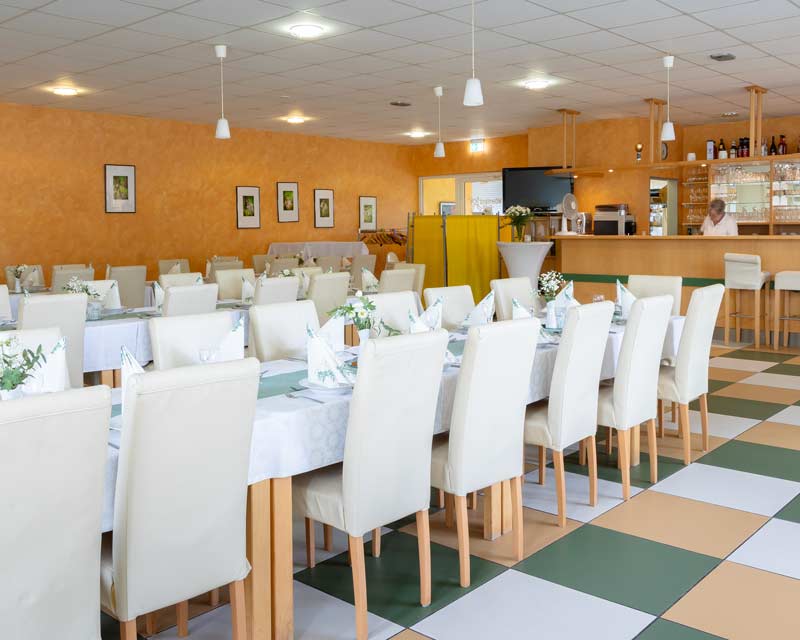 Innenaufnahme des Café Mölenland mit dekorierten Tischen und weißer Bestuhlung